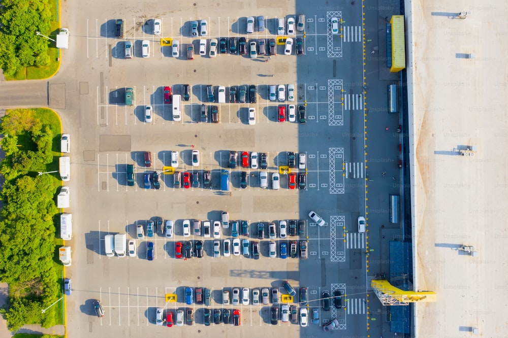 Aerial top down view of the parking lot with many cars of supermarket shoppers in the city grocery store