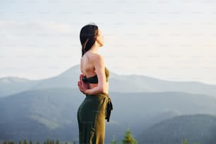 Sportive woman loves doing yoga. Majestic Carpathian Mountains. Beautiful landscape of untouched nature.