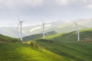 시골의 높은 산등성이 꼭대기에서 부는 강한 바람의 에너지로 전기를 생산하는 풍력 발전 단지.