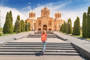 Visite turistiche e turismo a Yerevan. Viaggiatrice con zaino in spalla sale le scale che portano all'ingresso della Cattedrale di San Gregorio l'Illuminatore.