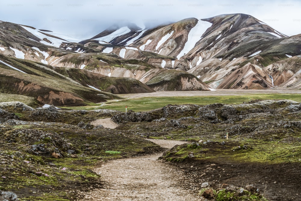 아이슬란드, 유럽의 고원에 있는 아름다운 Landmanalaugar 자갈 먼지 도로 길. 극단적 인 4WD 4x4 차량을위한 진흙 투성이의 거친 지형. 란드마날뢰이가르 풍경은 자연 트레킹과 하이킹으로 유명합니다.