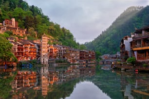 Chinese tourist attraction destination - Feng Huang Ancient Town (Phoenix Ancient Town) on Tuo Jiang River with Wanming Pagoda tower on sunset. Hunan Province, China