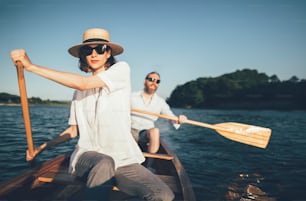 Los jóvenes copuples disfrutan de un paseo en canoa de verano por el lago.