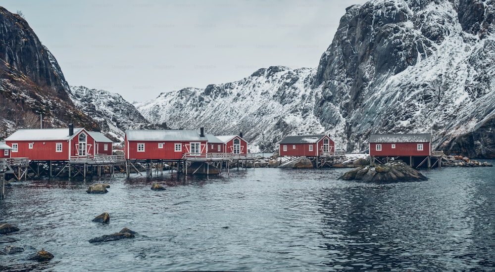 Panorama of Nusfjord authentic traditional fishing village with traditional red rorbu houses in winter in Norwegian fjord. Lofoten islands, Norway