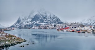 雪が積もった冬の赤いロルブの家があるロフォーテン島のレーヌ漁村のパノラマ。ロフォーテン諸島、ノルウェー