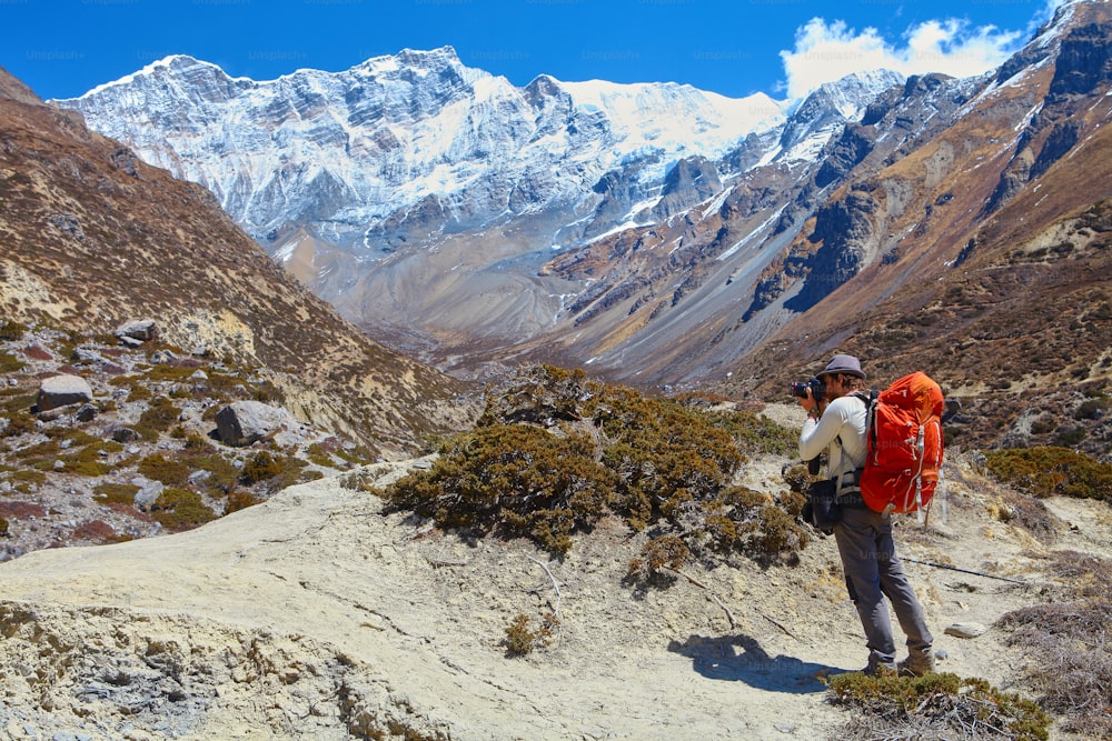 Hiking photographer taking pictures. Trek around Annapurna mount. 