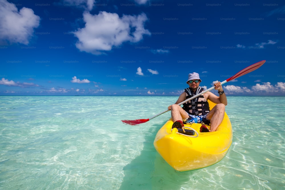 Giovane caucasico kayak in mare alle Maldive