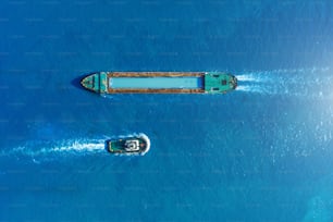 La chiatta della nave da carico e il rimorchiatore navigano per incontrarsi nel porto marittimo del porto, vista aerea
