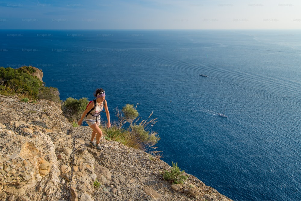 Girl hiking in the mountains above the sea