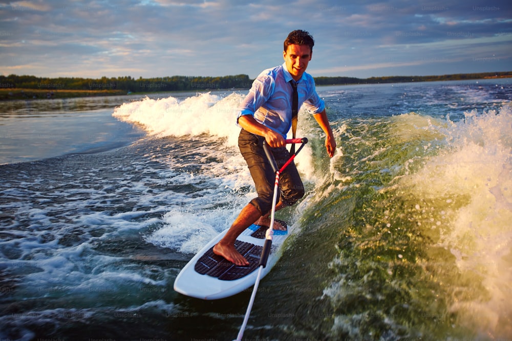 Active young man surfing on waves on vacation