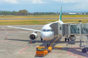 Avión de pasajeros con escaleras de embarque, espera de embarque de pasajeros y equipaje antes del vuelo, viaje al aeropuerto en verano