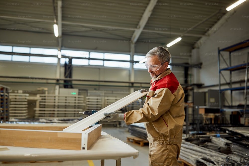 Männlicher Tischler bei der Herstellung eines Möbelstücks in einer Werkstatt.