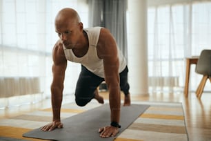 自宅でのスポーツトレーニング中にランニング腹筋運動をしているプランクポーズのアフリカ系アメリカ人アスリート。スペースをコピーします。