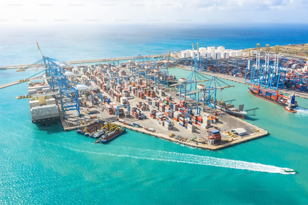Veduta aerea del porto marittimo con un numero enorme di container, gru per lo scarico delle merci. Grande nave al molo allo scarico. Concetto di trasporto marittimo