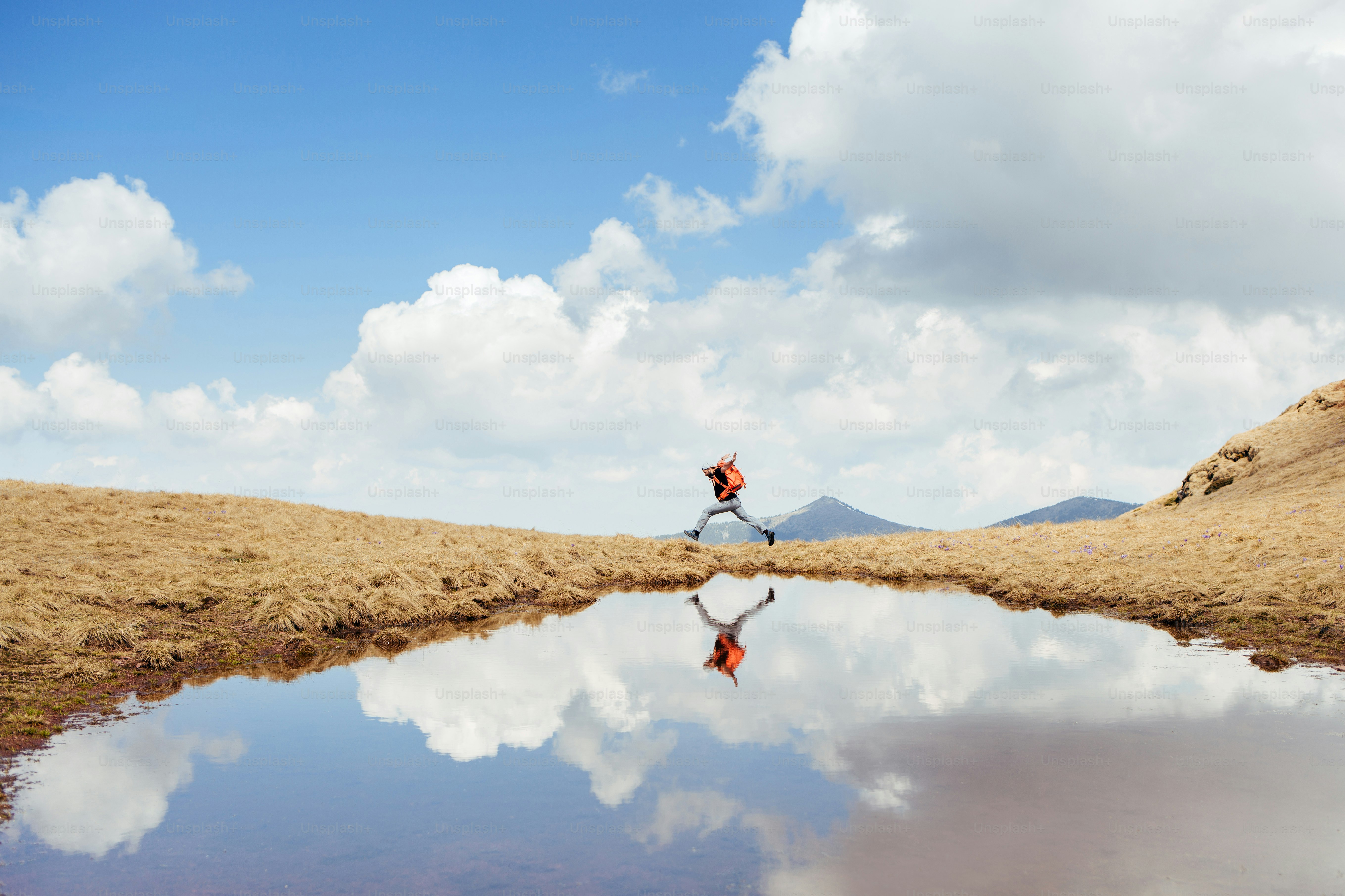 Cheerfull hiker running on the mountain.