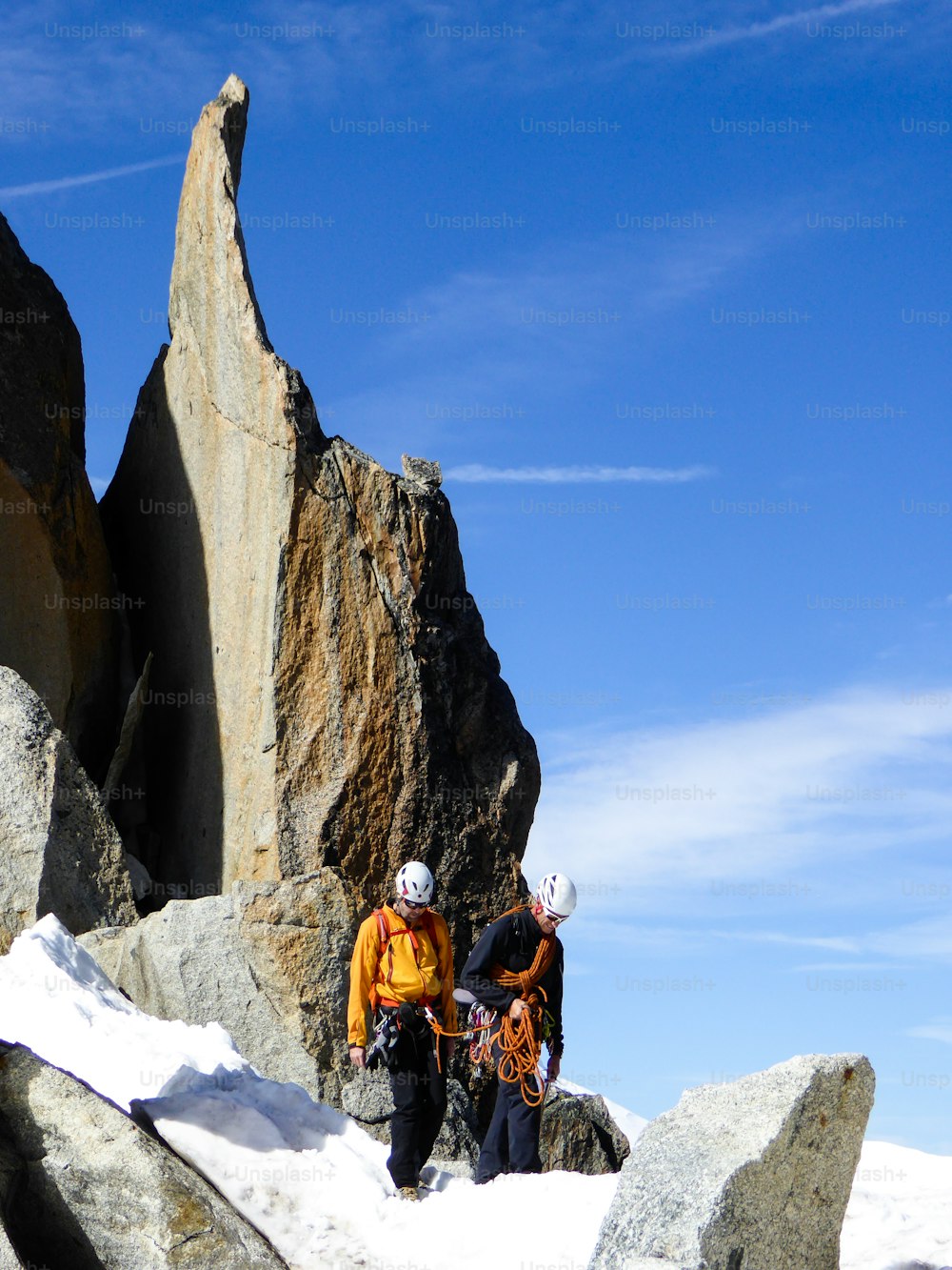 guía de montaña y un cliente masculino en una cresta rocosa que se dirige hacia una alta cumbre en los Alpes franceses cerca de Chamonix en un hermoso día de verano
