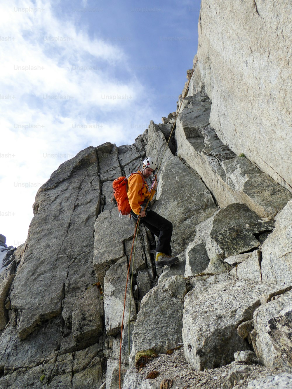 Un alpinista si cala in corda doppia da una ripida cresta rocciosa nelle Alpi francesi vicino a Chamonix