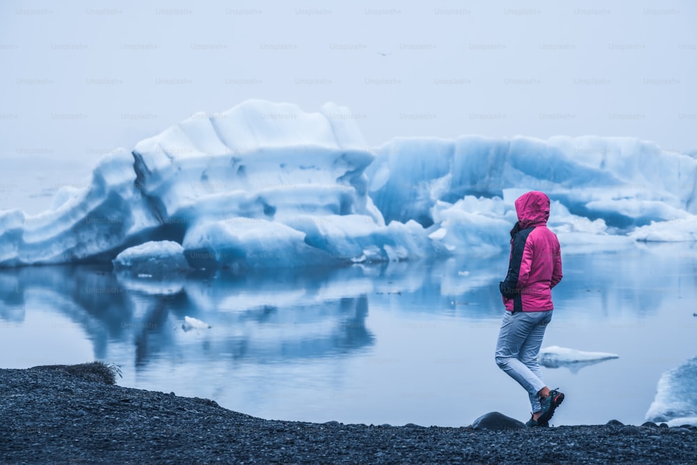 Mulher viajante viaja para Jokulsarlon bela lagoa glacial na Islândia. Jokulsarlon é um destino famoso no Parque Nacional Vatnajokull, sudeste da Islândia, Europa. Natureza gelada do inverno.