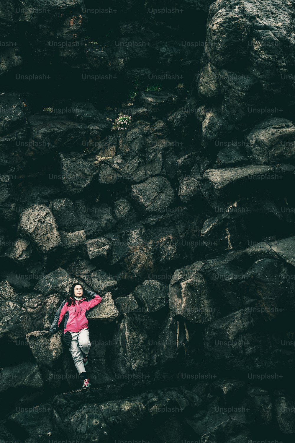 Mujer viajera en una cresta rocosa en Hellnar, Islandia. Concepto de turismo y exploración.