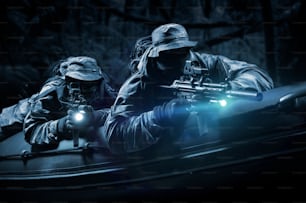 Deux combattants d’une unité spéciale se déplacent dans la forêt la nuit. Le concept d’opérations spéciales, de l’OTAN, de la guerre. Mixte