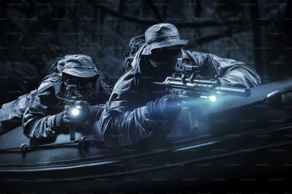 特殊部隊の2人の戦闘員が夜の森の中を移動する。特殊作戦、NATO、戦争の概念。ミクストメディア