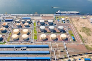 Aerial view of oil tankers moored at an oil storage silo terminal port and railway road infrastructure ground