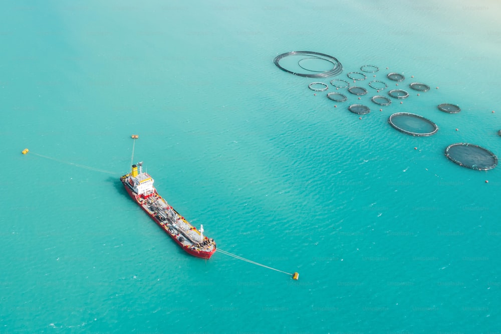 Veduta aerea cargo petroliera ormeggiata nella baia, vicino all'allevamento per l'allevamento ittico