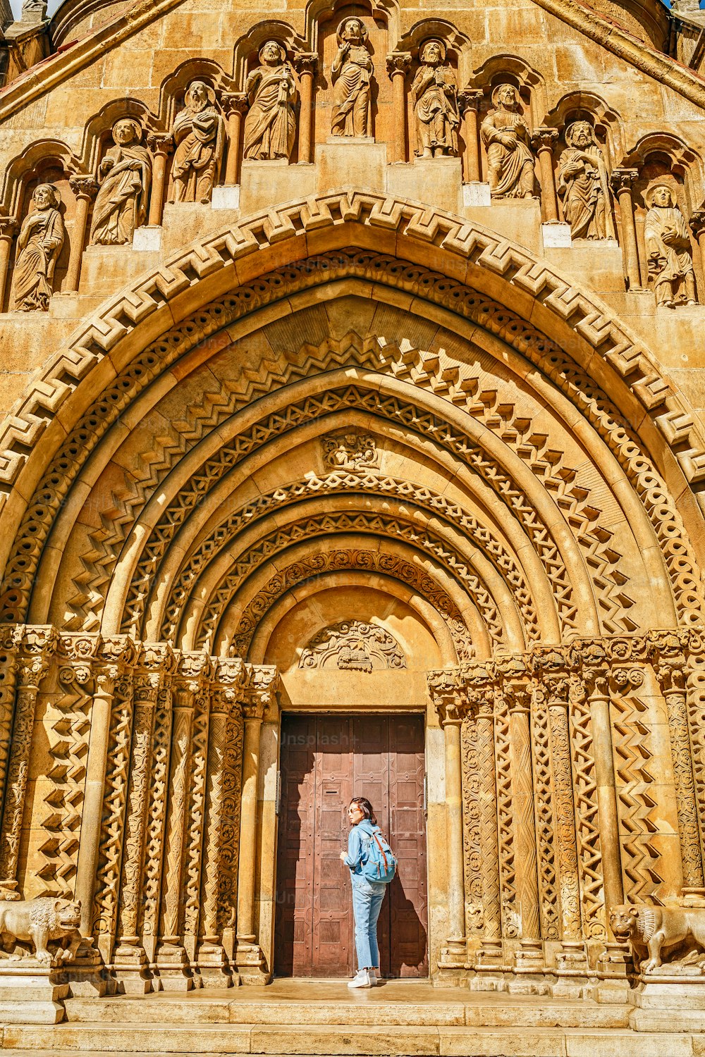 Voyageuse femme heureuse devant l’entrée de la chapelle de Jak dans le château de Vajdahunyad à Budapest, Hongrie.