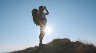 The traveler with backpack climbing the mountain