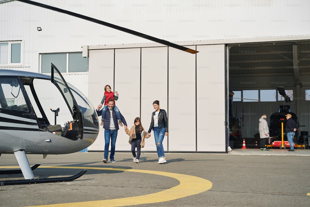 Mamá y papá cariñosos que pasan tiempo juntos mientras llevan a sus encantadores hijos a una aventura en avión