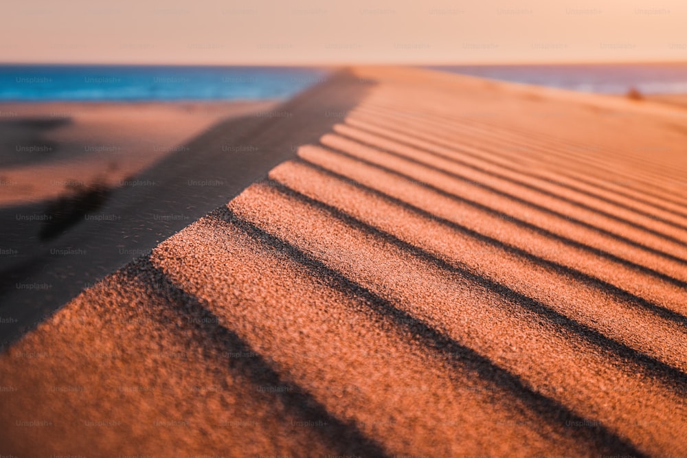 La spiaggia di Patara è un famoso punto di riferimento turistico e una destinazione naturale in Turchia. La vista maestosa delle dune di sabbia arancione e delle colline si illumina ai raggi del caldo tramonto.
