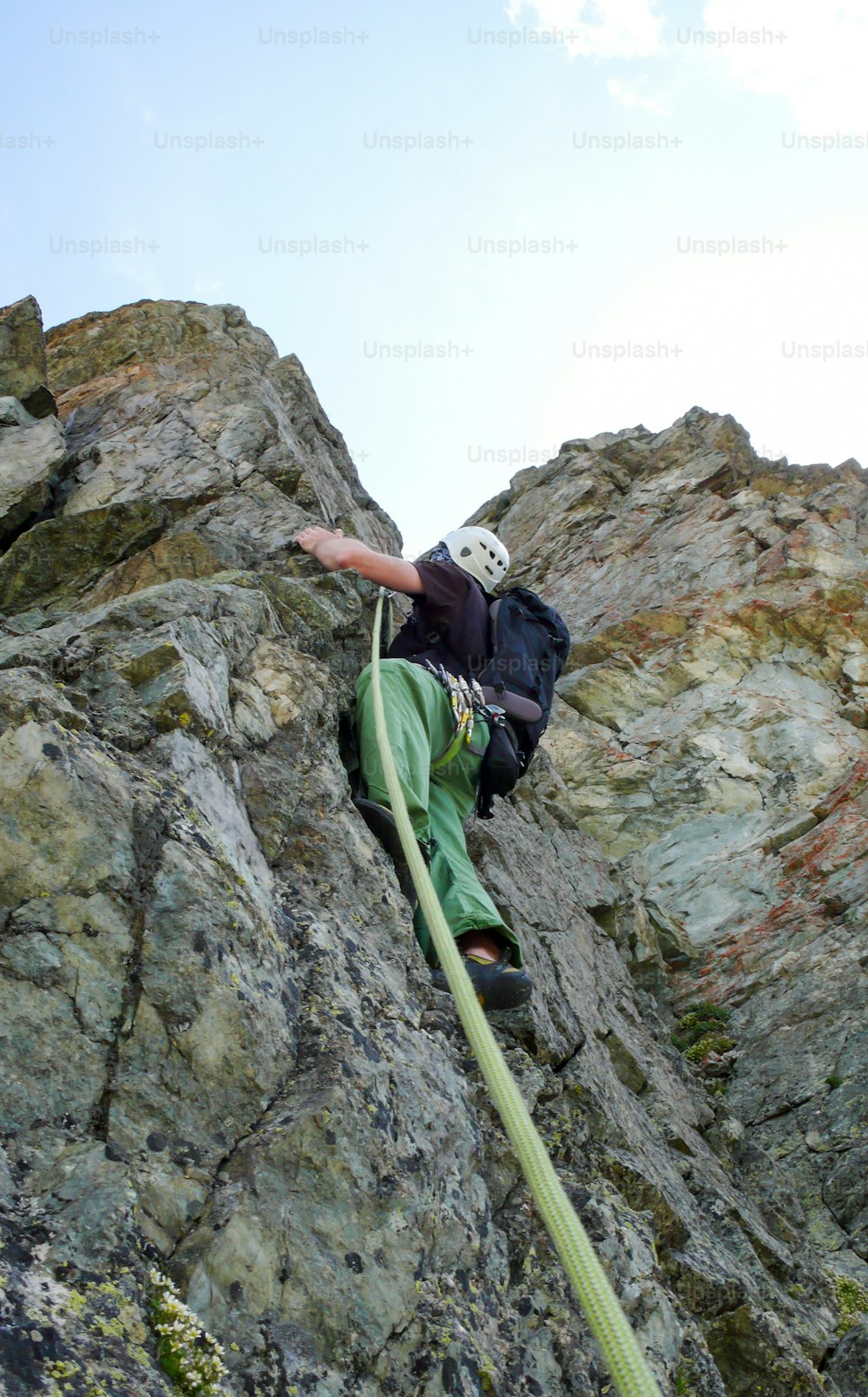 Un escalador en una ruta de escalada empinada en los Alpes
