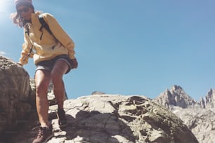 Excursionista joven con mochila que sube en el desierto de la montaña nevada