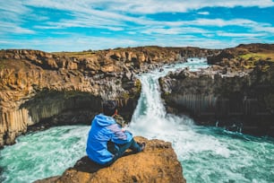 Escursionismo del viaggiatore nel paesaggio estivo islandese alla cascata di Aldeyjarfoss nel nord dell'Islanda. La cascata si trova nella parte settentrionale della Sprengisandur Road all'interno degli altopiani dell'Islanda.