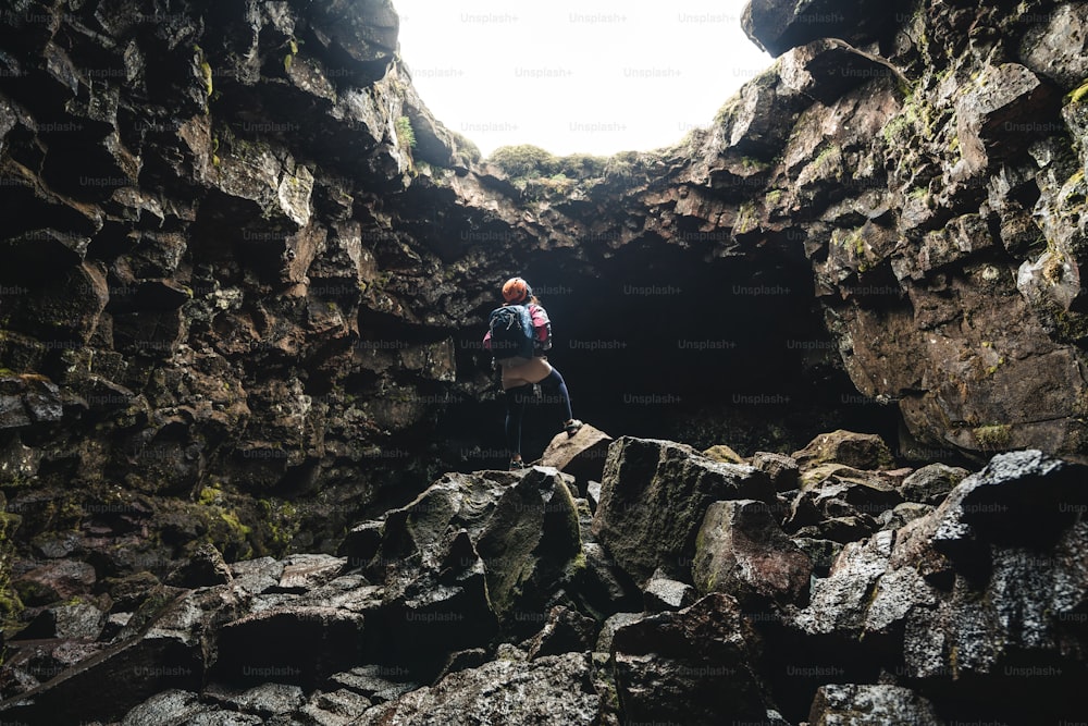 Une voyageuse explore un tunnel de lave en Islande. Raufarholshellir est un beau monde caché de grotte. C’est l’un des tunnels de lave les plus longs et les plus connus d’Islande, en Europe, pour des aventures incroyables.