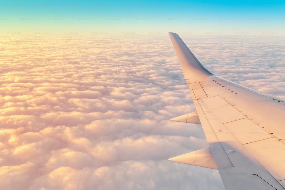 Reisen mit dem Flugzeug Konzept. Flügel des Flugzeugs mit malerisch bewölktem Himmelshintergrund