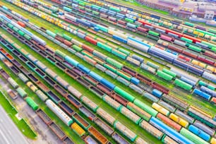 Cargo railway carriage. Aerial diagonally view from flying drone of colorful freight trains on the railway sort facility. Wagons with goods on railroad. Heavy industry, industrial concept scene