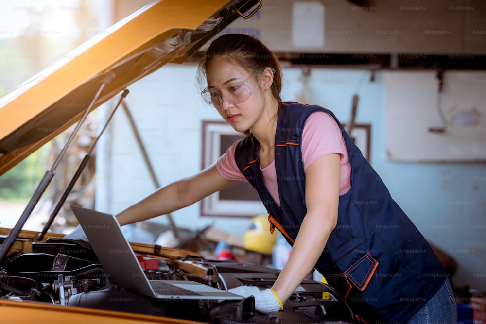 Una mujer mecánica de automóviles que repara automóviles con vista de capó abierto y verifica el nivel de aceite de motor para rellenar o limpiar en el servicio de garaje de automóviles