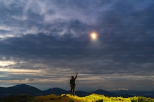O OVNI brilha em um homem de pé na montanha