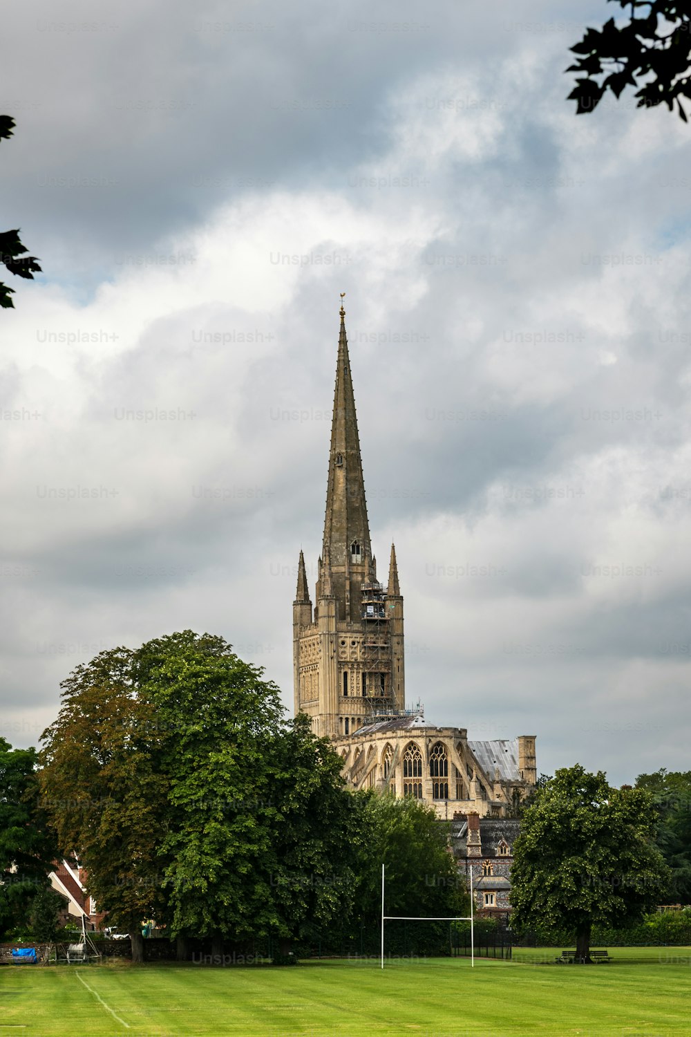 Back view of Norwich Cathedral against a cloudy sky, a temple dedicated to the Holy and Undivided Trinity completed in 1145.