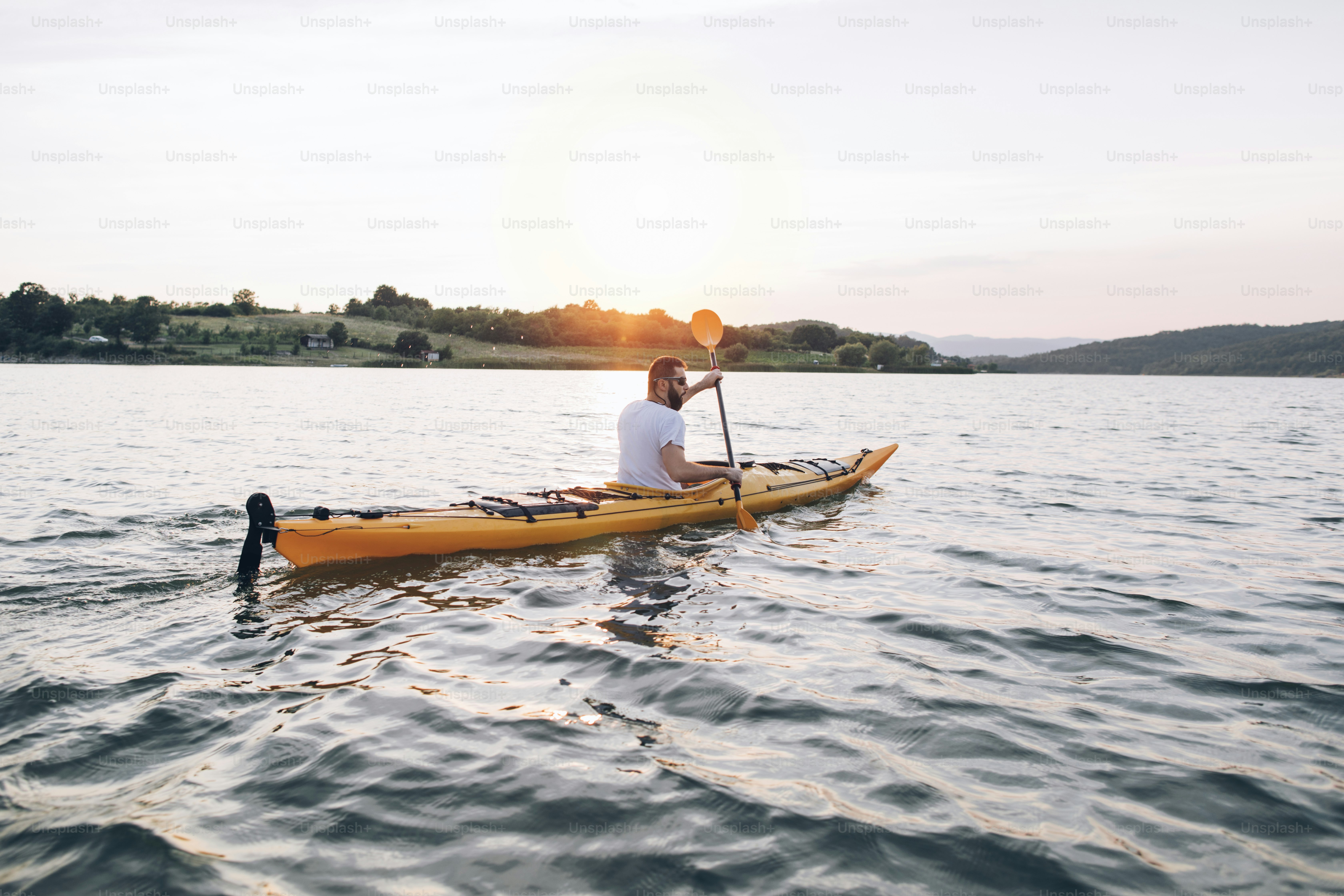 Man kayaker paddling the kayak at sunset sea. photo – Kayak Image on ...