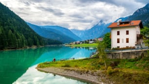 Beautiful mountain village landscape of Villapiccola and Lake Auronzo in Auronzo di Cadore, northern Italy. Nature and countryside panoramic landscape.