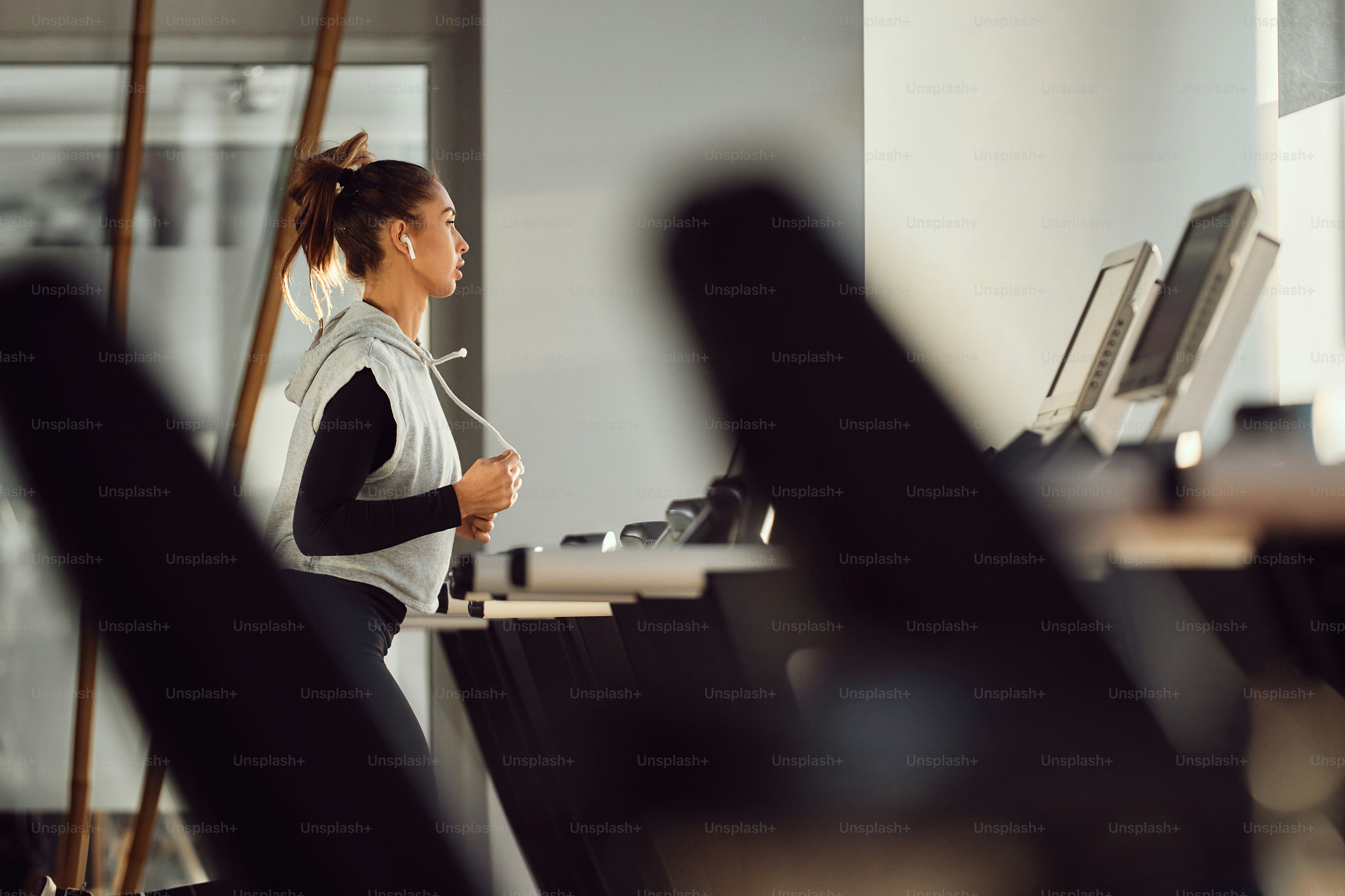 Athletic woman jogging on running track while working out in a gym ...