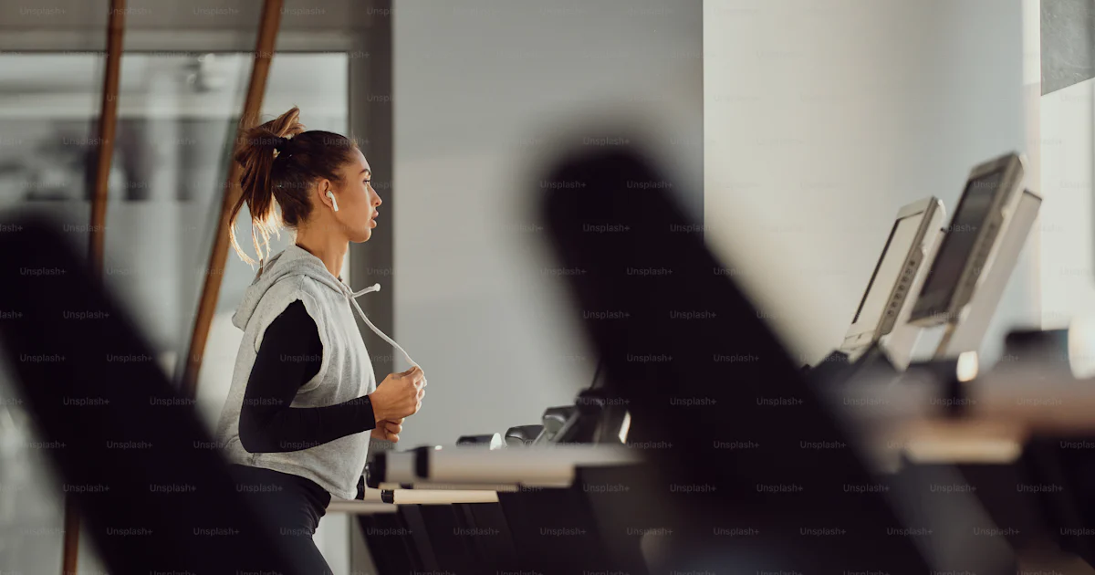 Running At Work Athletic woman jogging on running track while working out in a gym ...