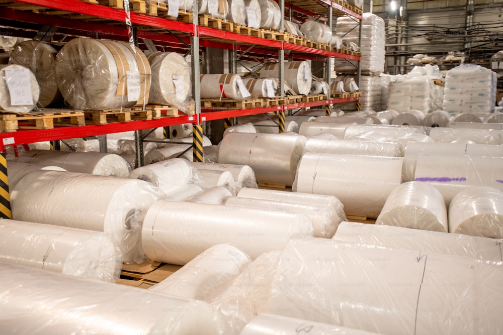 化学工場倉庫内で新たに生産したポリエチレンフィルムの大型ボビンを圧延・梱包・包装