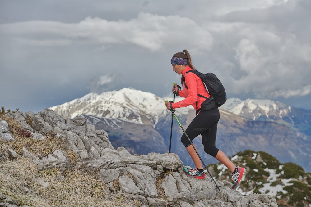 Mujer durante una caminata alpina con palos de palo