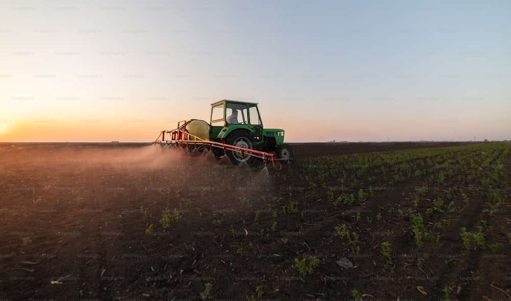 Tractor rociando pesticidas en campos de soja