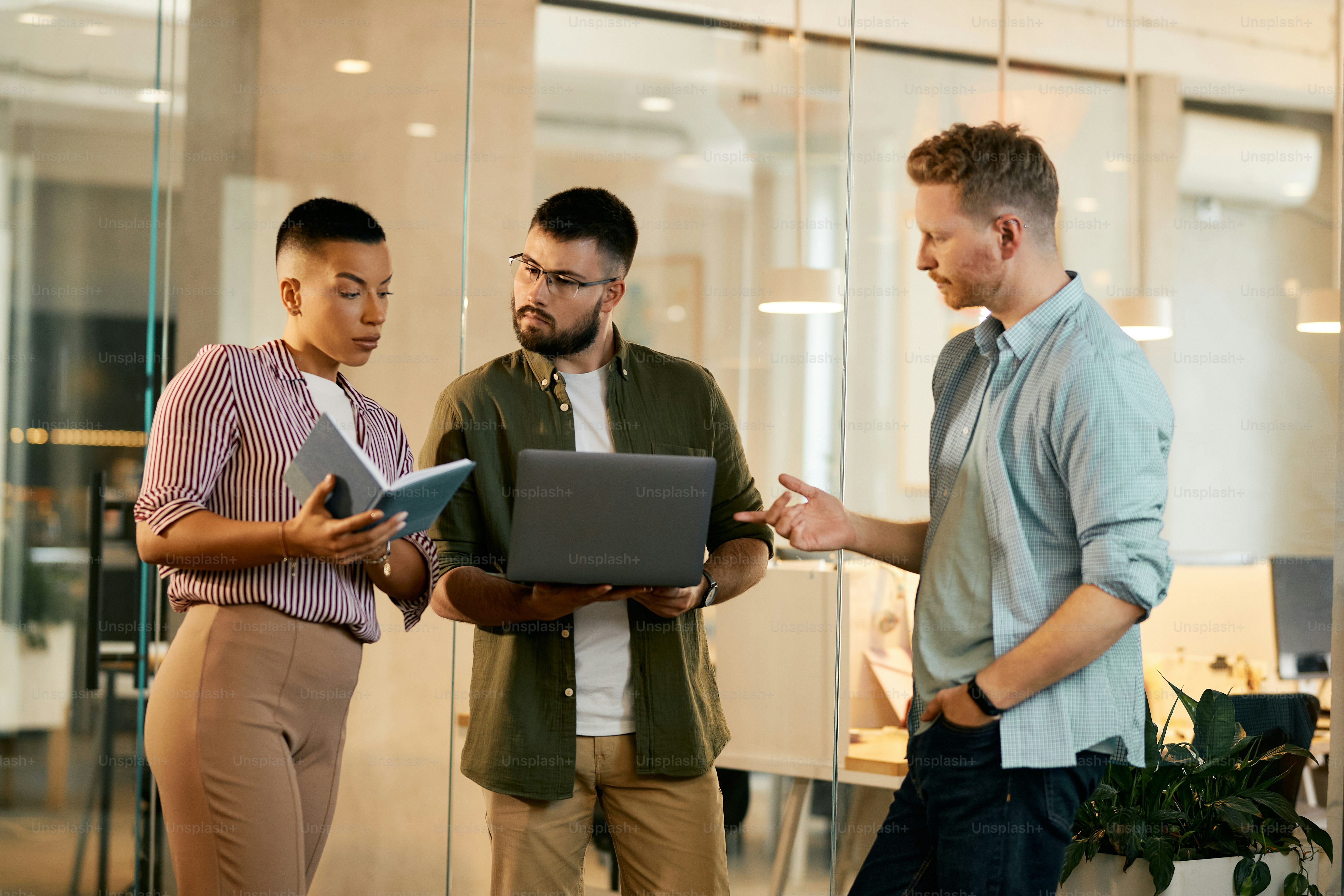 Grupo de empresarios que usan una computadora portátil mientras analizan datos comerciales durante una reunión en la oficina.