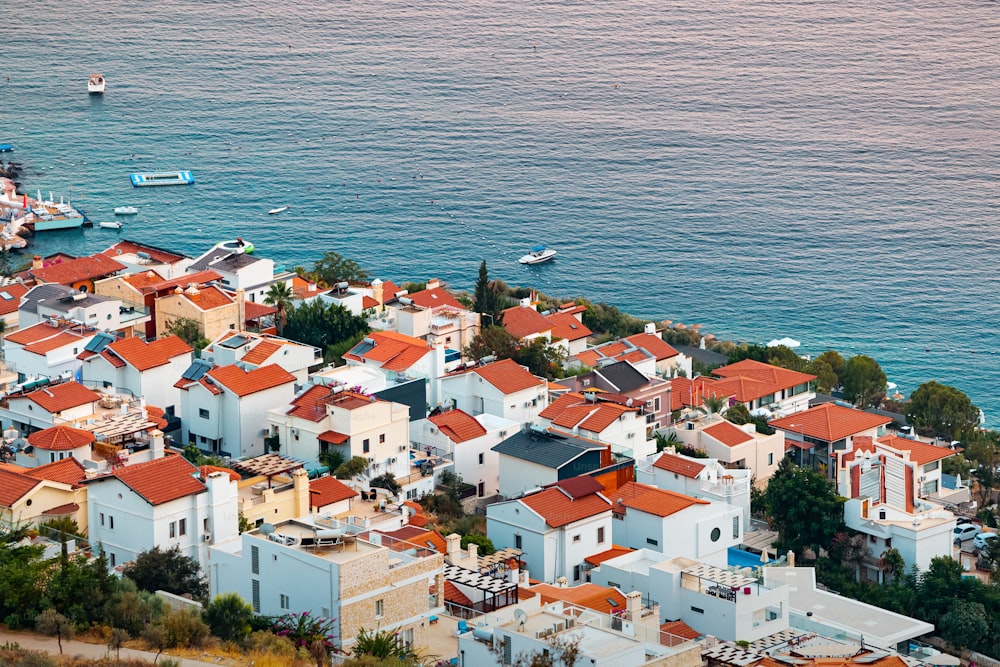 Vista aérea do pôr do sol da cidade turística costeira na costa do Mediterrâneo. Porto romântico e moradias com telhados vermelhos à espera de turistas