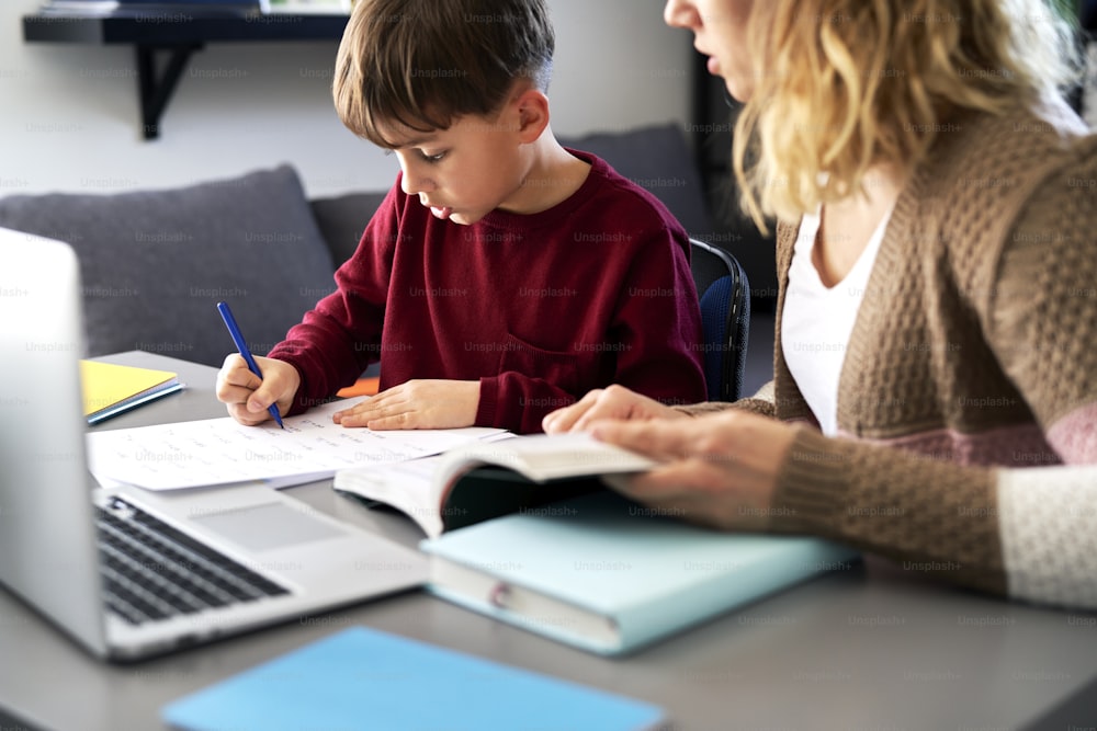 Boy doing homework with his mother during the lockdown